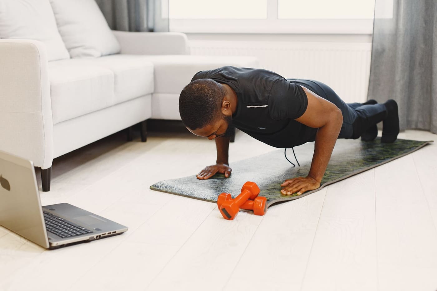 A man doing a push-up on a mat in a modern living room